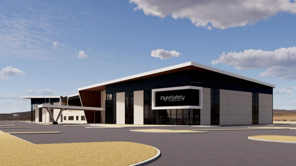 A modern FlightSafety International building with a covered entrance and large windows, surrounded by a parking lot under a blue sky.